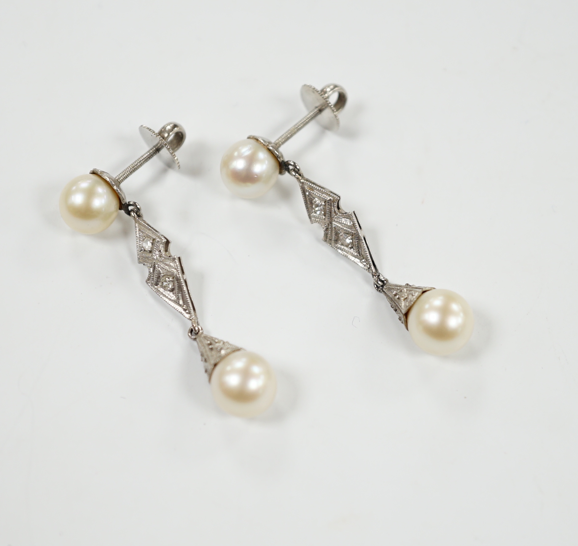 A pair of white metal, two stone cultured pearl and two stone diamond chip set drop earrings, 37mm, gross weight 6.1 grams.